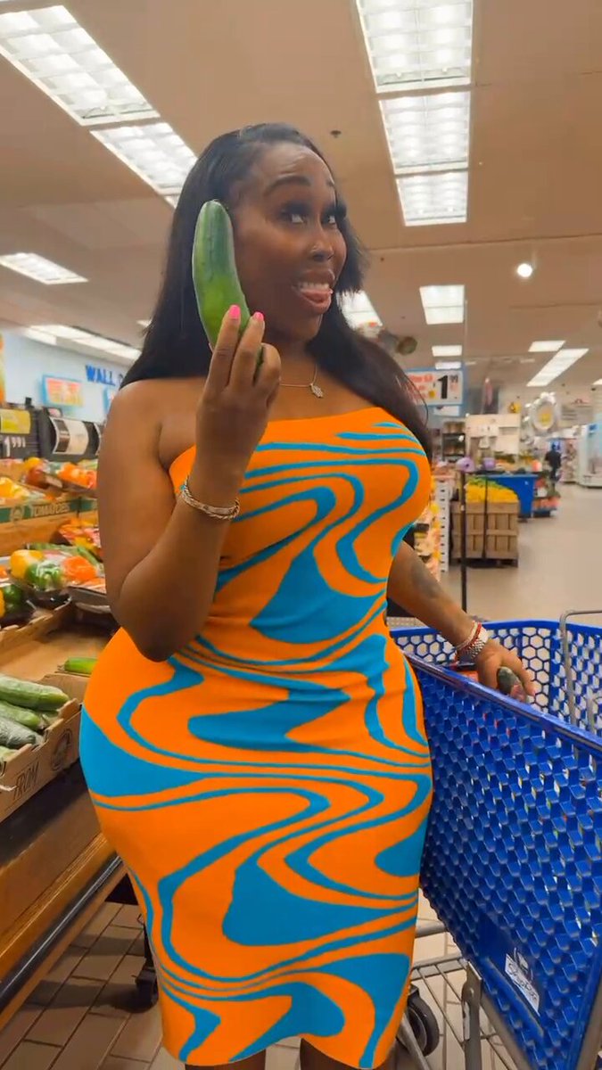 Does size matter? She is in the grocery store holding two cucumbers